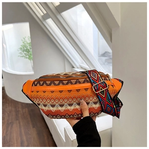 Detail of orange ethnic waist bag with colorful woven geometric patterns and embroidery