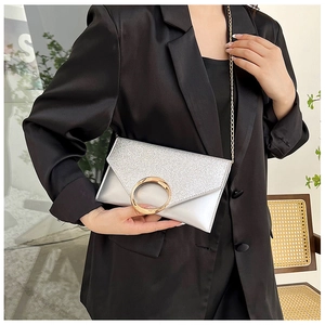Detail of silver envelope clutch bag with sequin flap and gold ring hardware lock