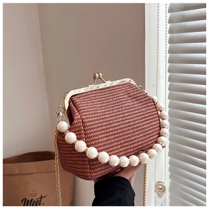 Détail du sac coquillage tissé terre cuite avec fermoir doré et anse en perles chic