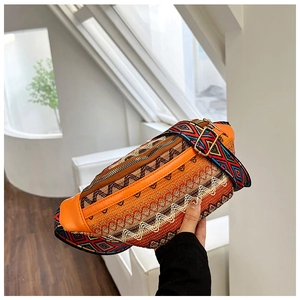 Detailed view of bohemian orange embroidered waist bag with colorful geometric patterns