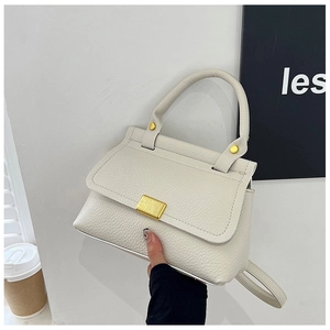 Close-up of cream lychee texture leather handbag with golden metal square buckle detail