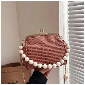 Détail d'un sac tressé couleur caramel avec anse en perles et fermoir métallique