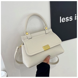 Detailed shot of white lychee textured leather bag with elegant golden metal clasp