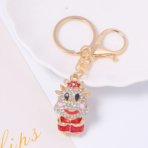 Golden zodiac ox keychain with white rhinestones and red Chinese outfit details