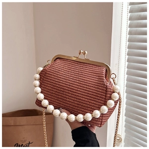 Détail du sac à main tissé avec décoration de perles et fermoir en métal doré