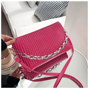 Detail showing pleated rose pink PU leather bag with silver chain and shoulder strap