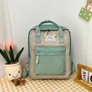Detail of mint green and beige contrast backpack on a yellow checkered tablecloth