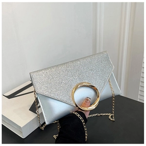 Detail of silver envelope bag with glitter texture, gold ring hardware and chain strap