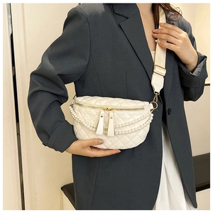 Détail du sac banane blanc matelassé avec chaîne de perles et bandoulière large