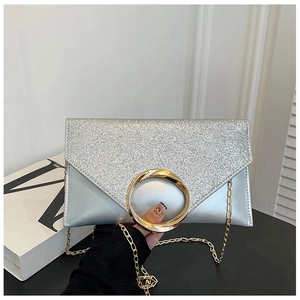 Macro shot of silver sequined envelope clutch with champagne gold ring handle and chain
