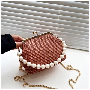 Détail d'un sac tressé marron avec fermoir doré et anse en perles blanches élégante