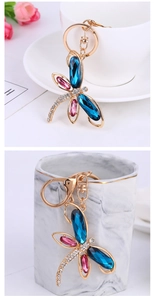 Detailed view of dragonfly keychain featuring large blue pink gems and white rhinestones
