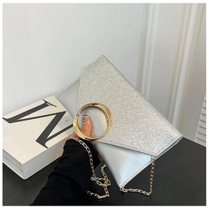Detail of silver envelope clutch with glitter texture and gold metal ring buckle