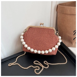 Détail du sac tissé beige avec poignée en perles et bandoulière en chaîne dorée