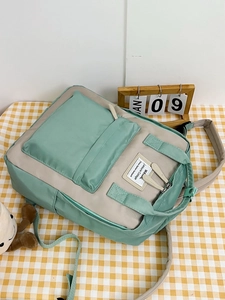 Detailed top view of mint green and beige contrast college backpack on plaid background