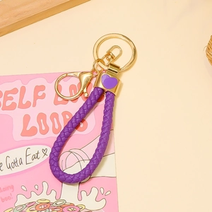 Détail d'un porte-clés en cuir violet avec fermoir doré et petit pendentif cœur