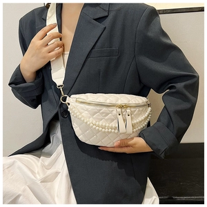 Détail du sac de poitrine blanc matelassé avec chaînes de perles et large bandoulière