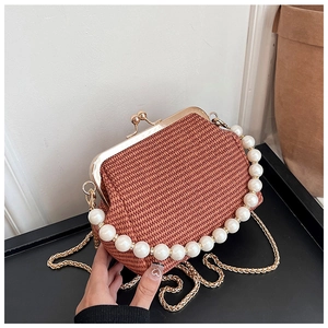 Gros plan détaillé du sac tressé style paille avec anse en perles et fermoir doré