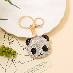 Detailaufnahme eines Pandabären-Schlüsselanhängers mit glitzernden Strasssteinen und Karabiner