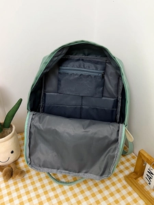 Detailed interior of the green backpack showing functional pockets and zipper compartment