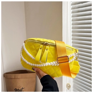 Détail d'un sac banane jaune matelassé avec chaîne en perles et large bandoulière