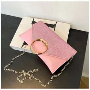 Detail of pink envelope clutch with glitter flap and circular gold metal buckle