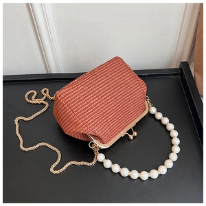 Détail du sac coquille tissé avec grande poignée en perles et chaîne dorée