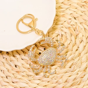 Close-up of golden crab keychain with sparkling rhinestones and metal lobster clasp