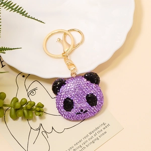 Detailansicht eines lila Panda-Schlüsselanhängers mit Kristallen und goldenem Karabinerhaken