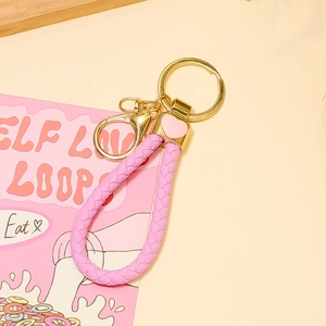 Vue détaillée du porte-clés en cuir PU tressé rose avec fermoir doré et cœur