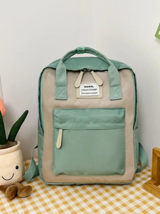 Detail of mint green and beige contrasting student backpack with WAWAL patch logo