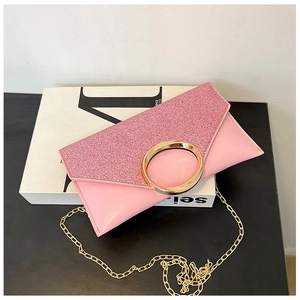 Detail of pink glitter envelope clutch bag with gold round metal buckle and chain strap