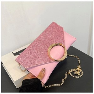 Detail of pink glitter envelope clutch with large golden round metal buckle and chain