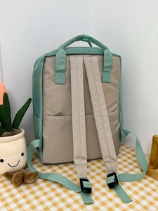 Detail of adjustable straps and top handle on the two-tone mint green school backpack