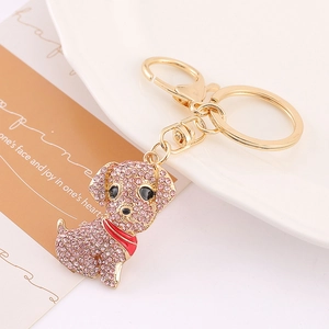 Détail du porte-clés chien en strass roses avec fermoir en métal doré sur l'assiette