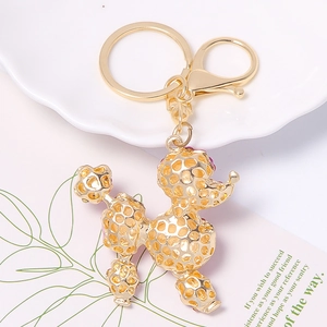 Golden poodle keychain with purple rhinestones on a decorative white tray