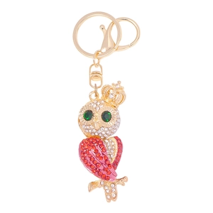 Sparkling crystal owl keychain with green eyes and red wings on a gold metal base