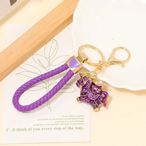 Detail of purple woven leather keychain with enamel pony charm and golden lobster clasp