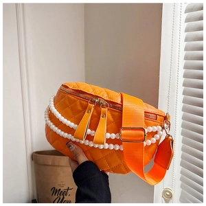 Détail du sac banane matelassé orange avec chaîne en perles élégante et bandoulière