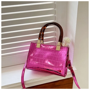 Detail of fuchsia mock croc tote bag with glossy finish and amber-style top handles