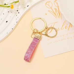 Dettaglio portachiavi in pelle con strass rosa con anello e chiusura in metallo dorato