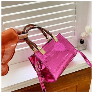 Detailed macro shot of glossy fuchsia crocodile texture handbag with amber resin handles