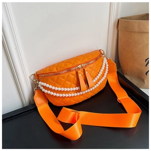Détail du sac banane orange matelassé avec chaîne de perles blanches et bandoulière nylon