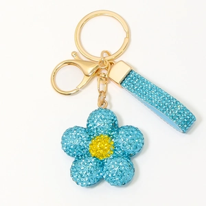 Vue détaillée du porte-clés fleur avec strass bleu ciel et fermoir mousqueton doré