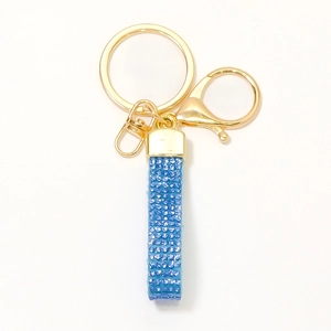 Portachiavi in strass azzurro con anello dorato e chiusura a moschettone su bianco
