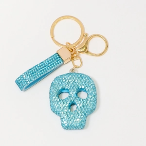 Vue détaillée du porte-clés tête de mort en strass bleu clair avec fermoir doré poli