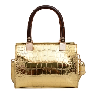 Glossy gold crocodile pattern handbag with amber ring handles and crossbody strap