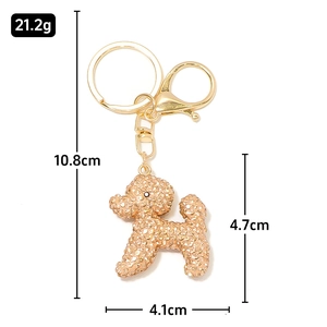 Vue détaillée du porte-clés caniche serti de strass avec anneau et crochet en métal doré