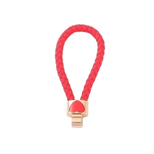 Close-up of red woven leather rope keychain with gold metal heart-shaped clasp detail