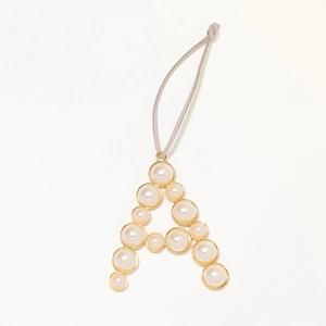 Golden keychain with letter A charm featuring pearl inlay and grey hanging strap